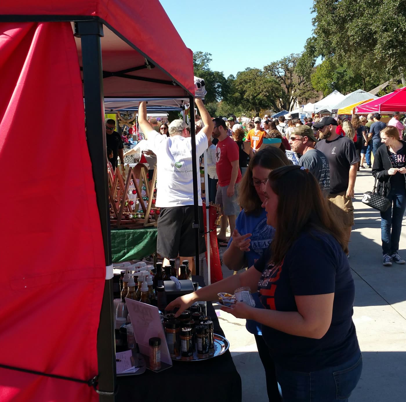 Shoppers at the Texas Flame And Smoke tent at an outdoor market