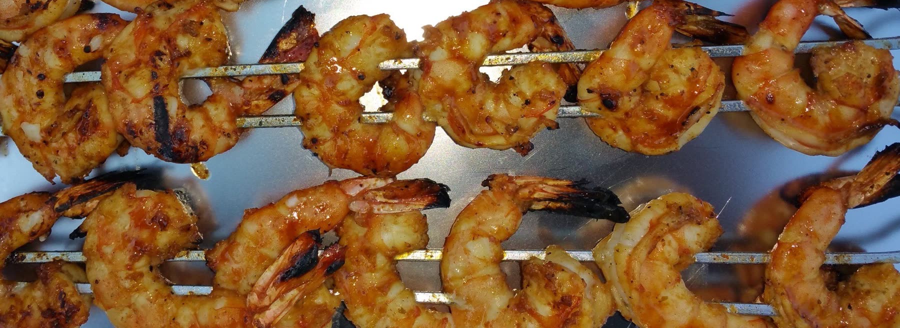 Seasoned shrimp skewers on the grill
